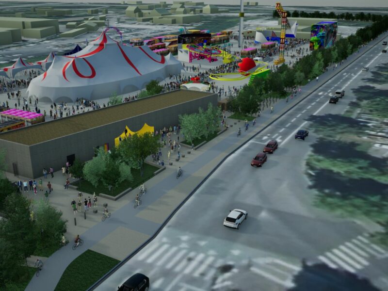 On voit des chapiteaux, un pavillon d'accueil et des attraction sur un espace aménagé pour recevoir des fêtes le long de la route